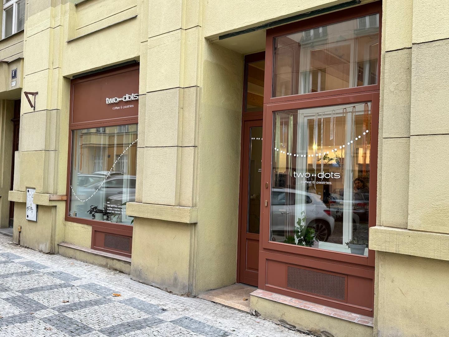 Storefront of two dots coffee & pastries, specialty coffee shop in Prague